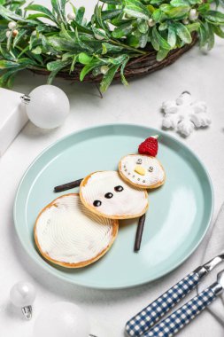 Lezzetli kardan adam gözlemeleri ve açık arkaplanda Noel süslemeleri olan tabaklar.