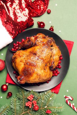 Lezzetli tavuklu tabak, Noel Baba şapkası ve yeşil arka planda Noel dekoru.