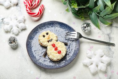 Krepten yapılmış kardan adam, krem şanti ve grunge masasında Noel dekoru.