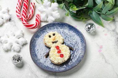 Krepten yapılmış kardan adam, krem şanti ve grunge masasında Noel dekoru.