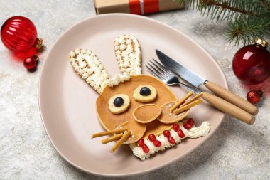 Krep, meyve ve Noel dekorundan yapılmış tavşanlı tabaklar grunge masasında, yakın plan