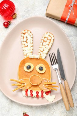 Krep, meyve ve Noel dekorundan yapılmış tavşanlı tabaklar grunge masasında, yakın plan