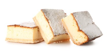 Beyaz zemin üzerinde şeker tozu olan lezzetli peynirli turta parçaları.