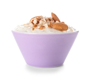 Beyaz arka planda lezzetli sütlaç, kuru üzüm ve badem.