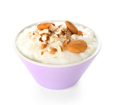 Beyaz arka planda lezzetli sütlaç, kuru üzüm ve badem.