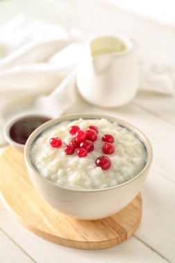 Lezzetli sütlaç, kızılcık ve reçel ile beyaz ahşap masa.