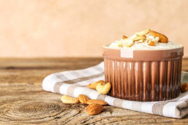 Tahta masada lezzetli sütlaç, kaju ve badem fıstıklı kase.