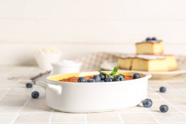 Taze yaban mersinli leziz peynirli turta. Beyaz fayans üzerinde pişirme şeklinde.