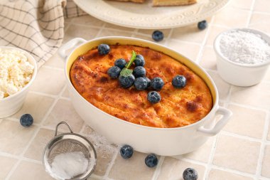 Taze yaban mersinli leziz peynirli turta ve beyaz fayans masasında malzemeler.