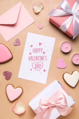 Yazılı kart Mutlu VALENTINE Günü, kurabiyeler, mumlar ve bej arkaplanda hediyeler