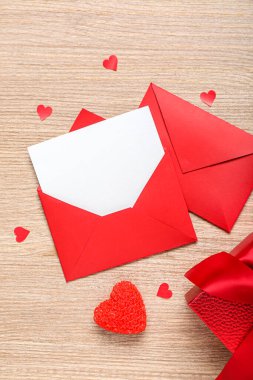 Boş mektup, hediye ve tahta arka planda kalpler. Sevgililer Günü kutlaması