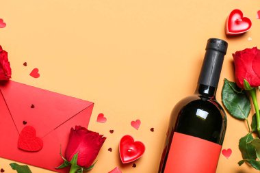 Güllü zarf, bir şişe şarap ve bej arka planda kalpler. Sevgililer Günü kutlaması
