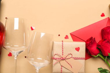 Güllü zarf, hediye ve bej arka planda gözlük. Sevgililer Günü kutlaması