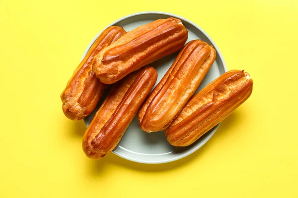 Plate Tasty Eclairs Yellow Background — Stock Photo, Image
