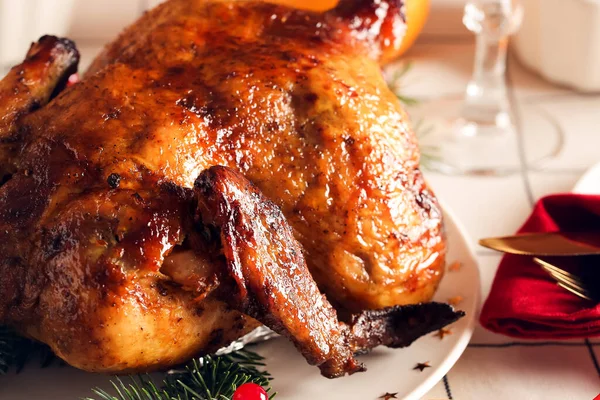 Plate with Christmas chicken on dining table in room, closeup