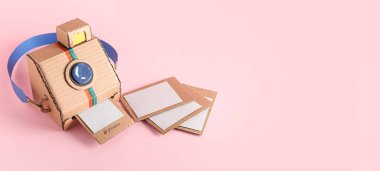 Pembe arkaplanda resimli karton fotoğraf makinesi ve metin için boşluk
