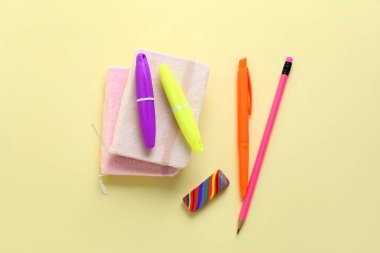 Renk arkaplanı üzerine not defterleri olan farklı kırtasiye