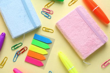 Renk arkaplanı üzerine not defterleri olan farklı kırtasiye setleri, yakın plan