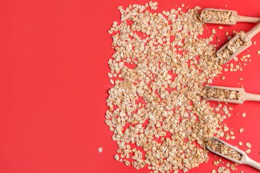 Kırmızı arkaplanda çiğ yulaf ezmeli Scoops