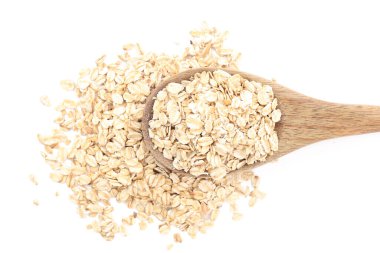 Beyaz arka planda çiğ yulaf ezmeli ahşap kaşık, yakın plan.