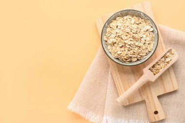 Tahta tahta tahta, kase ve arka planda çiğ yulaf ezmesi.