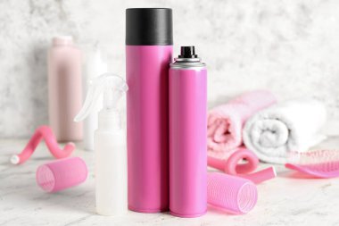 Işık masasında bigudili saç spreyleri, yakın plan.