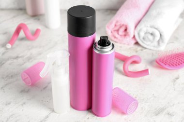 Işık masasında bigudili saç spreyleri, yakın plan.