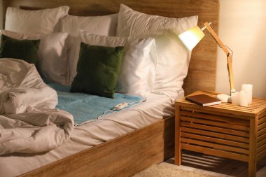 Geceleri yatak odasında elektrikli ısıtıcı pedi olan bir yatak.