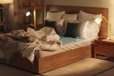 Geceleri yatak odasında elektrikli ısıtıcı pedi olan bir yatak.