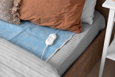 Elektrikli ısıtma yastığı. Yatakta kumanda var. Kapalı.