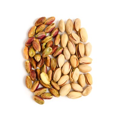 Soyulmamış ve soyulmamış fıstıklar beyaz arka planda izole edilmiş.