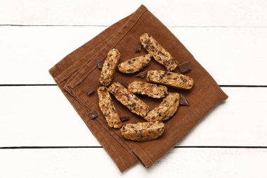 Kahverengi peçete ve lezzetli kurabiyeler beyaz ahşap arka planda.