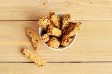 Tahta masada lezzetli bisküvilerle dolu bir fincan.