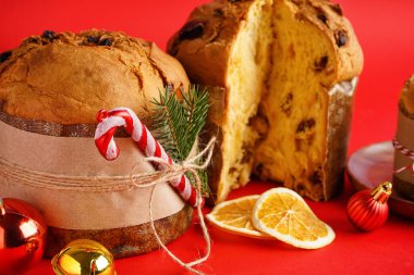 Kırmızı arka planda Noel dekoru olan Lezzetli Panettones