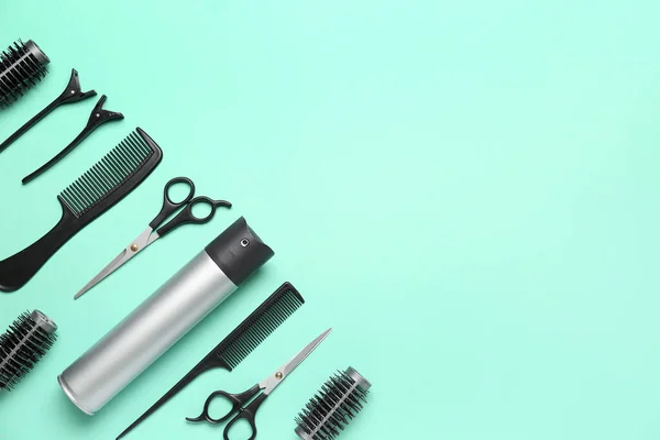 Hair spray with scissors and brushes on green background
