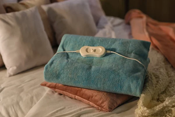 stock image Electric heating pad with pillow on bed at night, closeup