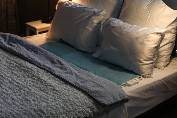 Bed with electric heating pad in dark room