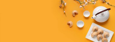 Fal kurabiyeli çay ve sarı zemin üzerinde erik ağacı dalları ve metin için yeri olan bir çay. Yeni yıl kutlaması