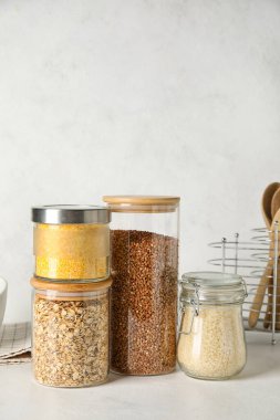 Hafif arka planda farklı tahıl gevrekleri olan kavanozlar