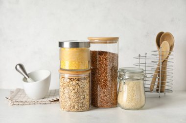 Hafif arka planda farklı tahıl gevrekleri olan kavanozlar