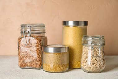 Masada farklı mısır gevreği bulunan kavanozlar renk arkaplanına karşı