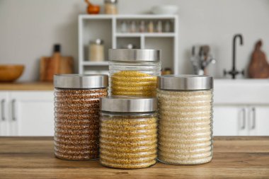 Mutfaktaki ahşap masada mısır gevreği olan kavanozlar.