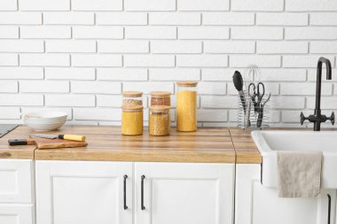 Kavanozlu mısır gevrekleri açık tuğla duvarın yanındaki tahta masada.