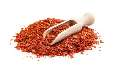 Bir yığın acı biber ve beyaz arka planda kepçe.