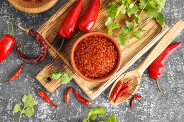 Ahşap tahta tahta, arka planda bir kase acı biber taneleri.