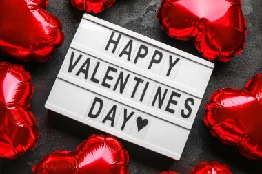 Yazılı pano Mutlu VALENTINE Günü ve koyu arkaplanda balonlar