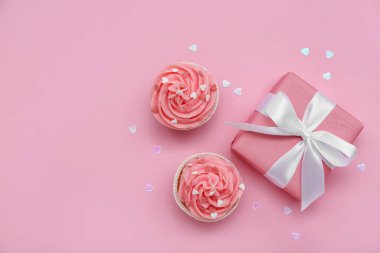 Tatlı kekler, kalpler ve hediye pembe arka planda Sevgililer Günü için