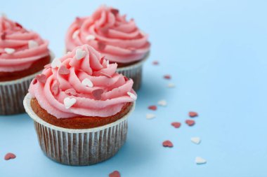 Mavi arka planda Sevgililer Günü için kalpleri olan lezzetli kekler, yakın plan.