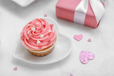 Beyaz arkaplanda Sevgililer Günü için lezzetli kek, kalp ve hediye tabağı, yakın plan.