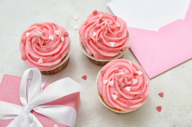 Beyaz arka planda Sevgililer Günü için üzerinde boş kart olan lezzetli kekler ve zarf.